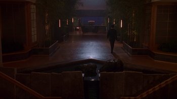 Movie still from “Johnny Mnemonic” (1995), directed by Robert Longo – A person walking down a walkway at night time; Extreme Wide shot, High angle