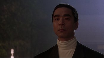 Movie still from “Johnny Mnemonic” (1995), directed by Robert Longo – A person wearing a suit and tie; Close Up shot, Low angle