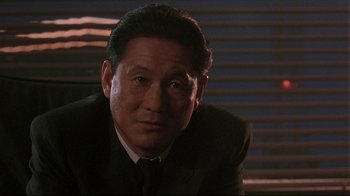 Movie still from “Johnny Mnemonic” (1995), directed by Robert Longo – A person wearing a suit and tie; Close Up shot, Low angle