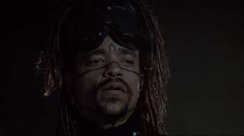 Movie still from “Johnny Mnemonic” (1995), directed by Robert Longo – A person with dreadlocks wearing goggles; Close Up shot, Low angle