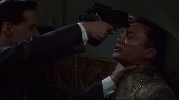 Movie still from “Johnny Mnemonic” (1995), directed by Robert Longo – A man holding a gun up to his head; Close Up shot, Over the shoulder angle