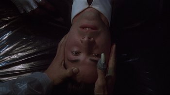 Movie still from “Johnny Mnemonic” (1995), directed by Robert Longo – A person holding a cell phone up to their face; Close Up shot, Overhead angle