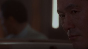 Movie still from “Johnny Mnemonic” (1995), directed by Robert Longo – A man's face in a dark room; Extreme Close Up shot, Low angle