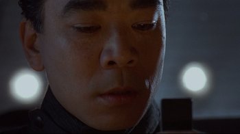 Movie still from “Johnny Mnemonic” (1995), directed by Robert Longo – A person's face with a light shining on them; Extreme Close Up shot, High angle