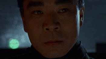 Movie still from “Johnny Mnemonic” (1995), directed by Robert Longo – A man's face in the dark; Close Up shot, Low angle