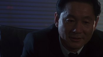 Movie still from “Johnny Mnemonic” (1995), directed by Robert Longo – A person wearing a suit and tie; Close Up shot, Low angle