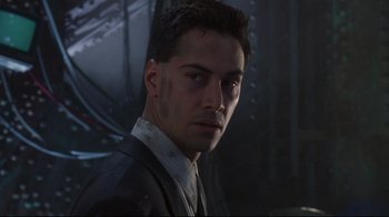 Movie still from “Johnny Mnemonic” (1995), directed by Robert Longo – A person wearing a suit and tie; Close Up shot, Low angle