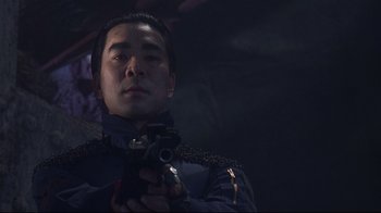Movie still from “Johnny Mnemonic” (1995), directed by Robert Longo – A man holding a gun while standing in a dark room; Close Up shot, Low angle