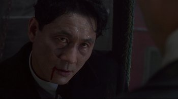 Movie still from “Johnny Mnemonic” (1995), directed by Robert Longo – A person with blood on his face; Close Up shot, Low angle