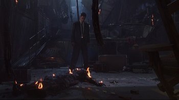 Movie still from “Johnny Mnemonic” (1995), directed by Robert Longo – A man standing next to fire in an abandoned building; Wide shot, High angle