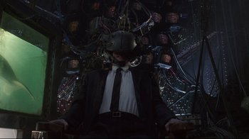 Movie still from “Johnny Mnemonic” (1995), directed by Robert Longo – A man in a suit and tie wearing a helmet; Wide shot, High angle