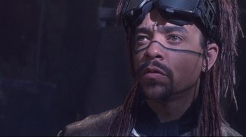 Movie still from “Johnny Mnemonic” (1995), directed by Robert Longo – A person wearing a helmet; Close Up shot, High angle