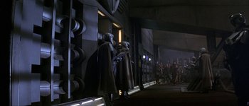 Movie still from “Judge Dredd” (1995), directed by Danny Cannon – A group of people standing next to each other on a street; Extreme Wide shot, Over the shoulder angle