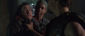 Movie still from “Judge Dredd” (1995), directed by Danny Cannon – A group of men standing next to each other holding guns; Close Up shot, Over the shoulder angle