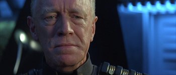 Movie still from “Judge Dredd” (1995), directed by Danny Cannon – An older man in a police uniform looking at the camera; Close Up shot, Over the shoulder angle