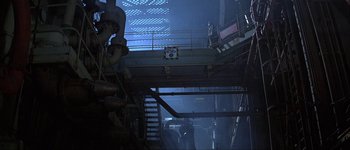 Movie still from “Judge Dredd” (1995), directed by Danny Cannon – Two people are standing on the stairs of a building; Extreme Wide shot, High angle