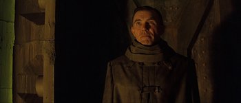 Movie still from “Judge Dredd” (1995), directed by Danny Cannon – A man in a trench coat and a neck scarf; Close Up shot, Low angle