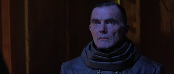 Movie still from “Judge Dredd” (1995), directed by Danny Cannon – A person wearing a jacket; Close Up shot, Over the shoulder angle