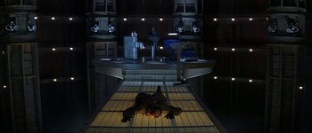 Movie still from “Judge Dredd” (1995), directed by Danny Cannon – A man laying on the ground in a dark room; Wide shot, Overhead angle