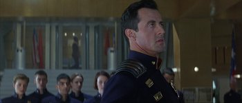 Movie still from “Judge Dredd” (1995), directed by Danny Cannon – A person wearing a uniform; Close Up shot, Over the shoulder angle