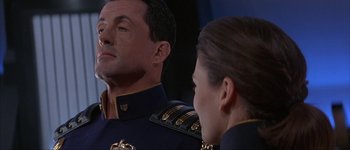 Movie still from “Judge Dredd” (1995), directed by Danny Cannon – A man and a woman in military uniforms looking at one another; Close Up shot, Low angle