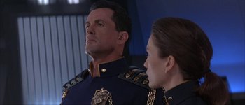 Movie still from “Judge Dredd” (1995), directed by Danny Cannon – A man and a woman standing next to each other; Close Up shot, Low angle