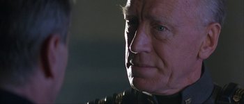 Movie still from “Judge Dredd” (1995), directed by Danny Cannon – An older man is looking into the distance; Close Up shot, Over the shoulder angle