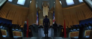 Movie still from “Judge Dredd” (1995), directed by Danny Cannon – A group of people standing in front of a room; Extreme Wide shot, Low angle
