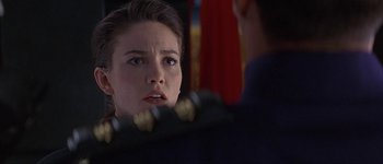 Movie still from “Judge Dredd” (1995), directed by Danny Cannon – A woman looking at a man in a blue suit; Close Up shot, Over the shoulder angle