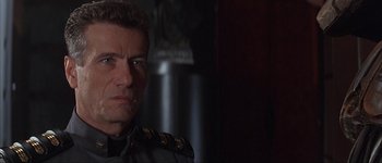 Movie still from “Judge Dredd” (1995), directed by Danny Cannon – A person wearing a military uniform; Close Up shot, Over the shoulder angle