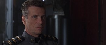 Movie still from “Judge Dredd” (1995), directed by Danny Cannon – A person wearing a military uniform; Close Up shot, Over the shoulder angle