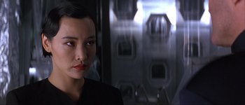 Movie still from “Judge Dredd” (1995), directed by Danny Cannon – A person wearing a suit and tie; Close Up shot, Over the shoulder angle