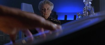 Movie still from “Judge Dredd” (1995), directed by Danny Cannon – An older woman is playing the piano in a dark room; Close Up shot, Low angle