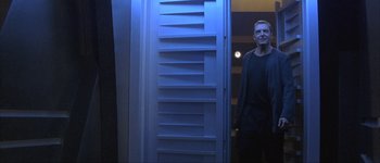 Movie still from “Judge Dredd” (1995), directed by Danny Cannon – A man standing in front of an open door; Medium shot, Low angle