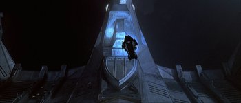 Movie still from “Judge Dredd” (1995), directed by Danny Cannon – A man is jumping off the top of a building; Extreme Wide shot, Overhead angle