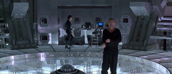 Movie still from “Judge Dredd” (1995), directed by Danny Cannon – A man and a woman are in a room; Wide shot, High angle