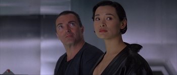 Movie still from “Judge Dredd” (1995), directed by Danny Cannon – A man and a woman standing next to each other; Close Up shot, Low angle