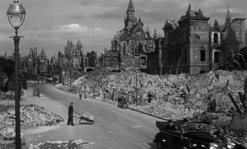 Movie still from “Judgment at Nuremberg” (1961), directed by Stanley Kramer – An old black and white photo of a man standing on the side of the road; Extreme Wide shot, High angle