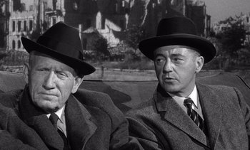 Movie still from “Judgment at Nuremberg” (1961), directed by Stanley Kramer – Two men in suits and hats sitting next to each other; Close Up shot, High angle