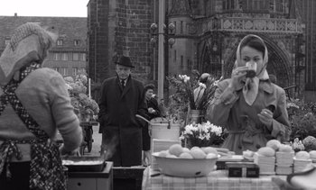 Movie still from “Judgment at Nuremberg” (1961), directed by Stanley Kramer – An older man and woman are eating at an outdoor table; Medium shot, Over the shoulder angle