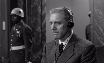 Movie still from “Judgment at Nuremberg” (1961), directed by Stanley Kramer – An older man wearing a suit and headphones; Close Up shot, Low angle