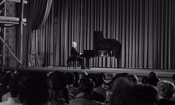 Movie still from “Judgment at Nuremberg” (1961), directed by Stanley Kramer – A man sitting at a piano in front of an audience; Wide shot, High angle
