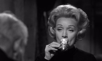 Movie still from “Judgment at Nuremberg” (1961), directed by Stanley Kramer – An older woman drinking a cup of coffee; Close Up shot, Over the shoulder angle
