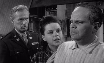 Movie still from “Judgment at Nuremberg” (1961), directed by Stanley Kramer – A group of people standing next to each other in a room; Close Up shot, Over the shoulder angle