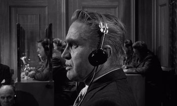 Movie still from “Judgment at Nuremberg” (1961), directed by Stanley Kramer – An older man wearing headphones in a courtroom; Close Up shot, Low angle