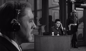 Movie still from “Judgment at Nuremberg” (1961), directed by Stanley Kramer – A man and a woman sitting in front of each other; Medium shot, High angle