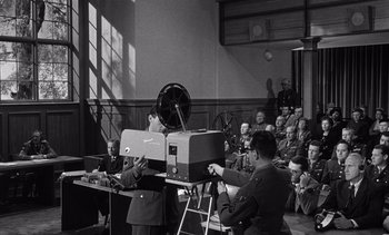 Movie still from “Judgment at Nuremberg” (1961), directed by Stanley Kramer – An old photo of people watching a movie; Wide shot, High angle