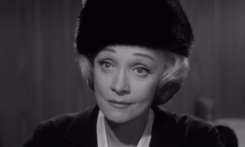 Movie still from “Judgment at Nuremberg” (1961), directed by Stanley Kramer – An older woman wearing a fur hat and a jacket; Close Up shot, Over the shoulder angle