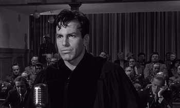 Movie still from “Judgment at Nuremberg” (1961), directed by Stanley Kramer – A black and white photo of a man with a microphone in front of a crowd; Close Up shot, Low angle