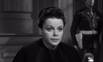 Movie still from “Judgment at Nuremberg” (1961), directed by Stanley Kramer – An old photo of a woman in a black outfit; Close Up shot, High angle